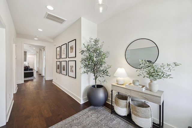 hallway with wood finished floors, baseboards, and recessed lighting