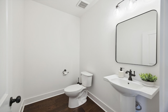 bathroom featuring baseboards, toilet, and wood finished floors