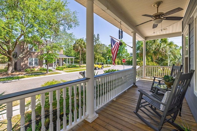 wooden terrace with covered porch and a ceiling fan