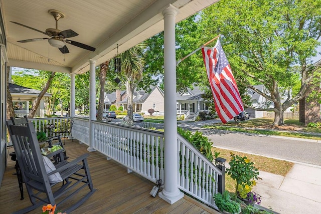 wooden terrace with a ceiling fan, a residential view, and covered porch