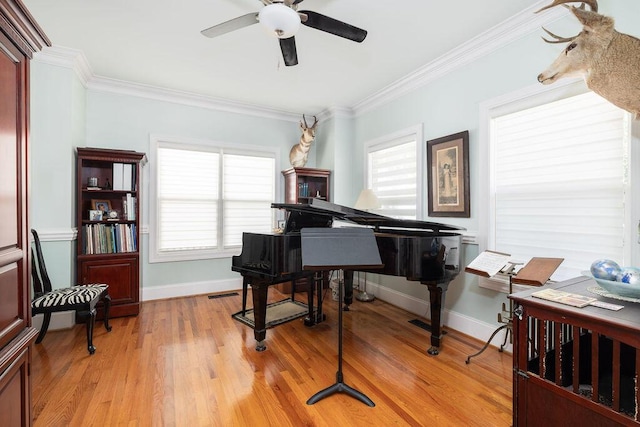 living area with a ceiling fan, baseboards, visible vents, crown molding, and light wood-style floors