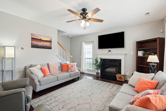 living room featuring a fireplace, dark hardwood / wood-style floors, and ceiling fan