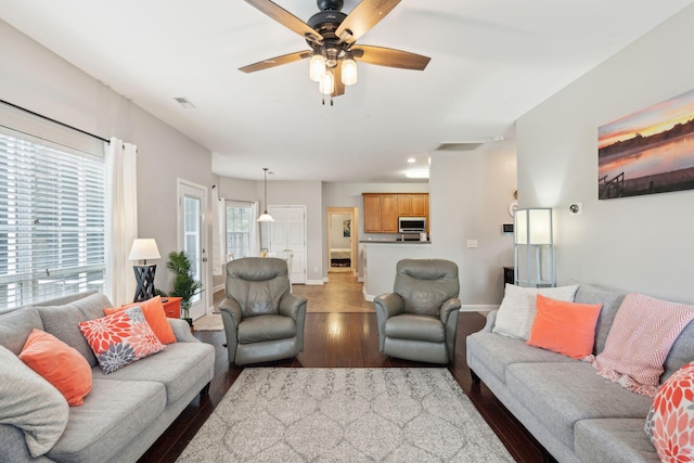 living room with dark hardwood / wood-style floors and ceiling fan