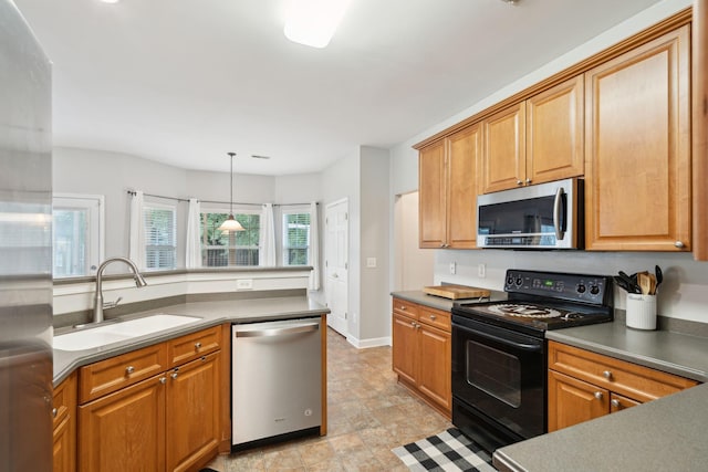 kitchen with pendant lighting, stainless steel appliances, and sink