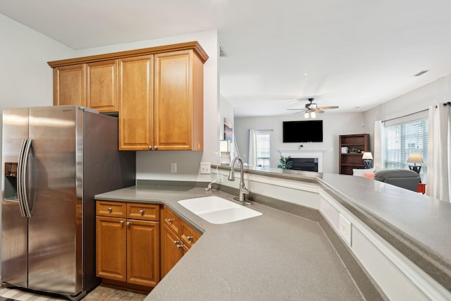 kitchen with ceiling fan, stainless steel refrigerator with ice dispenser, and sink