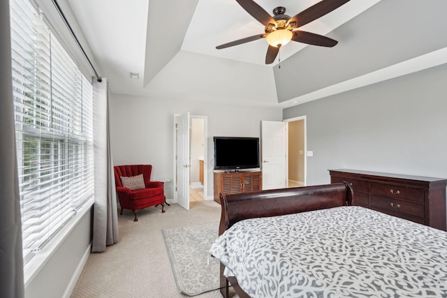 bedroom featuring a raised ceiling, connected bathroom, ceiling fan, and light colored carpet