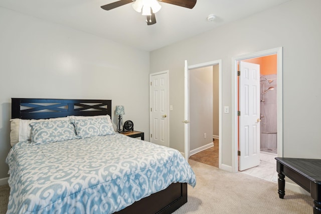 bedroom featuring ceiling fan, light colored carpet, a closet, and connected bathroom