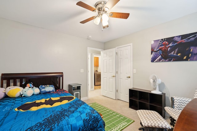 bedroom with light carpet, washer / clothes dryer, and ceiling fan