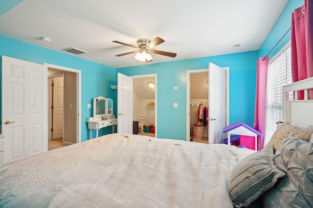 bedroom with a closet, ceiling fan, and a walk in closet