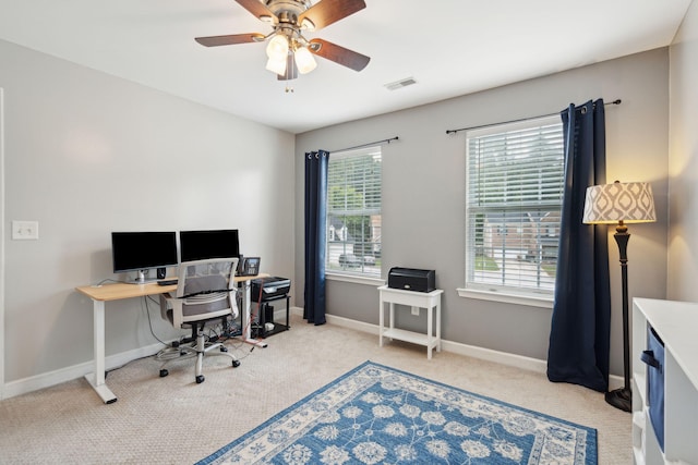 carpeted office space featuring ceiling fan