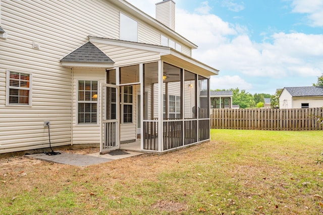 back of house with a sunroom and a yard