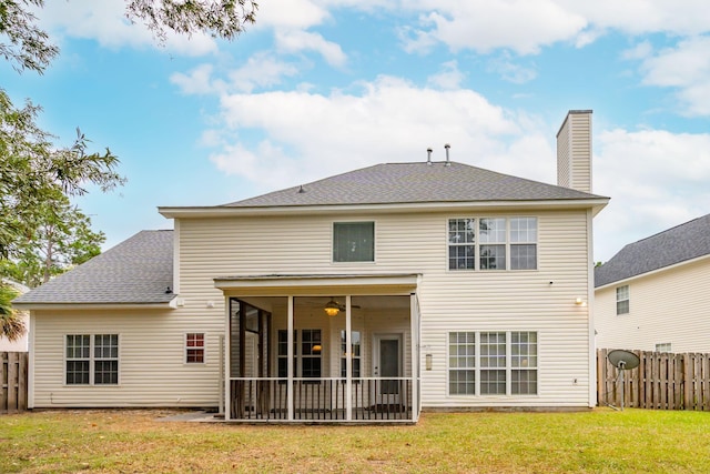 rear view of house featuring ceiling fan, a sunroom, and a yard