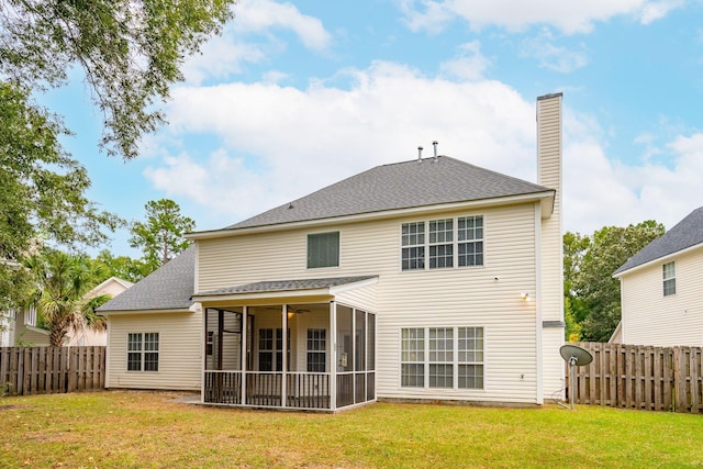 back of house featuring a sunroom and a lawn