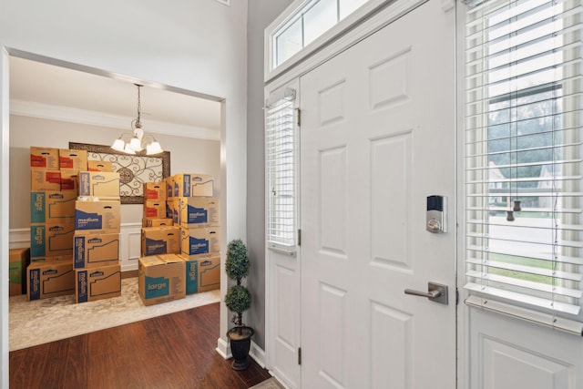 foyer entrance featuring ornamental molding, dark hardwood / wood-style floors, and a chandelier