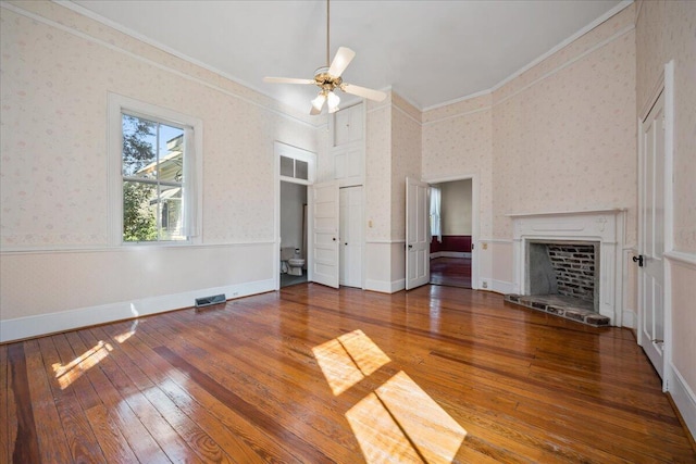 unfurnished living room with wood-type flooring, ornamental molding, and ceiling fan