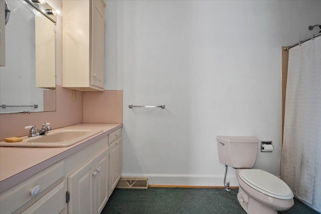 bathroom featuring vanity, curtained shower, and toilet