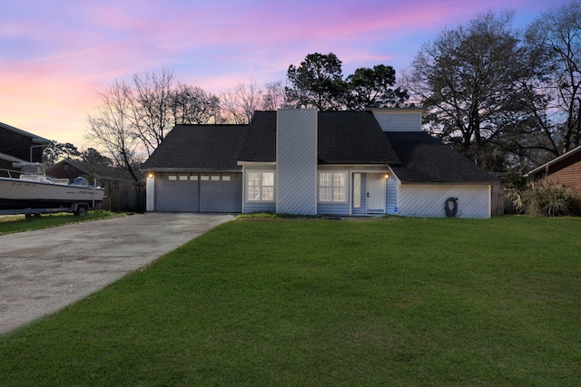 view of front facade with concrete driveway, an attached garage, a front lawn, and roof with shingles