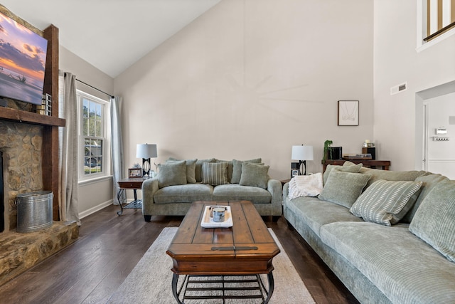 living area with dark wood finished floors, visible vents, high vaulted ceiling, and baseboards