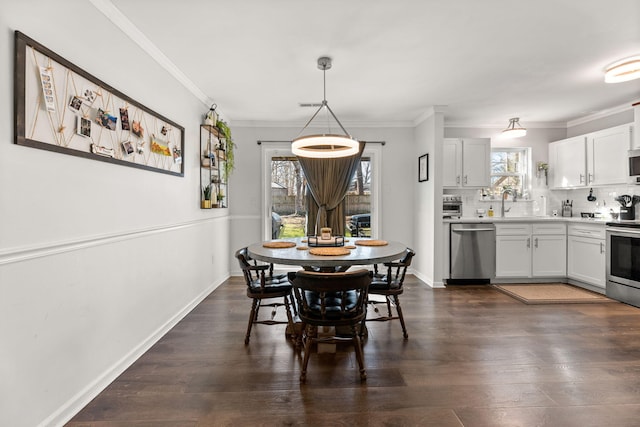 dining space with dark wood finished floors, crown molding, and baseboards