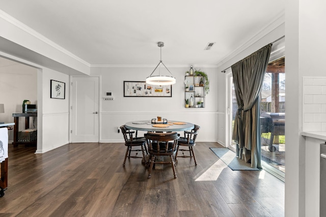 dining area with dark wood finished floors, visible vents, baseboards, and ornamental molding