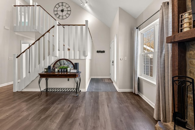 foyer entrance featuring stairs, lofted ceiling, wood finished floors, and baseboards