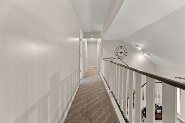 corridor featuring lofted ceiling, an upstairs landing, and light carpet