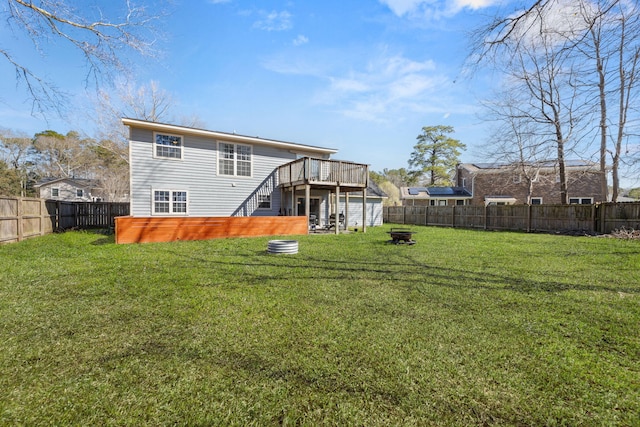 back of house featuring a fire pit, stairs, a yard, a deck, and a fenced backyard