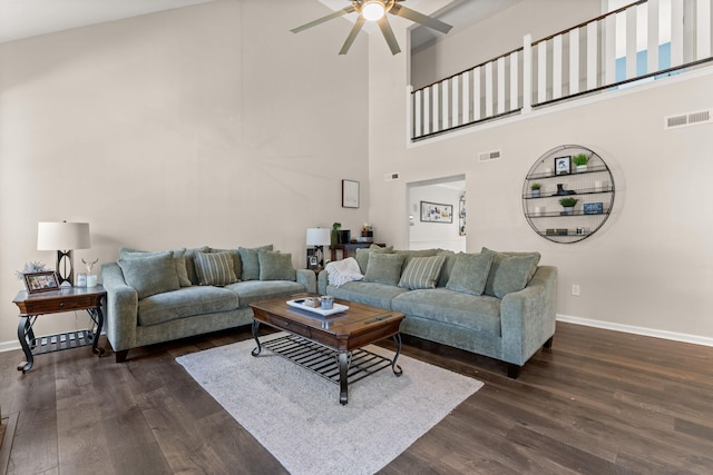 living area featuring visible vents, baseboards, dark wood-type flooring, and a ceiling fan