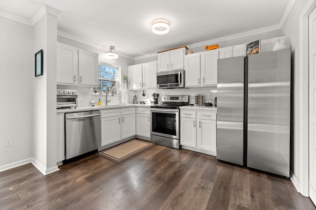 kitchen with a sink, light countertops, appliances with stainless steel finishes, crown molding, and tasteful backsplash