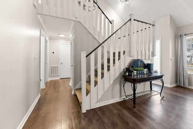 staircase featuring visible vents, baseboards, and hardwood / wood-style flooring