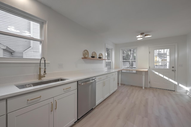 kitchen featuring stainless steel dishwasher, light hardwood / wood-style floors, white cabinets, and sink