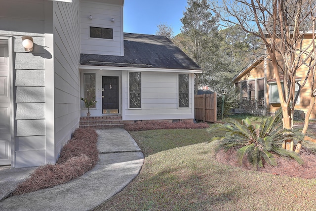 view of exterior entry with a lawn