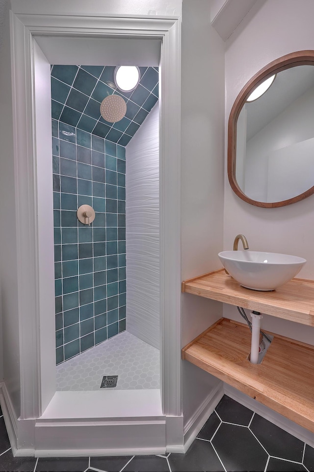 bathroom with tile patterned floors, tiled shower, sink, and vaulted ceiling