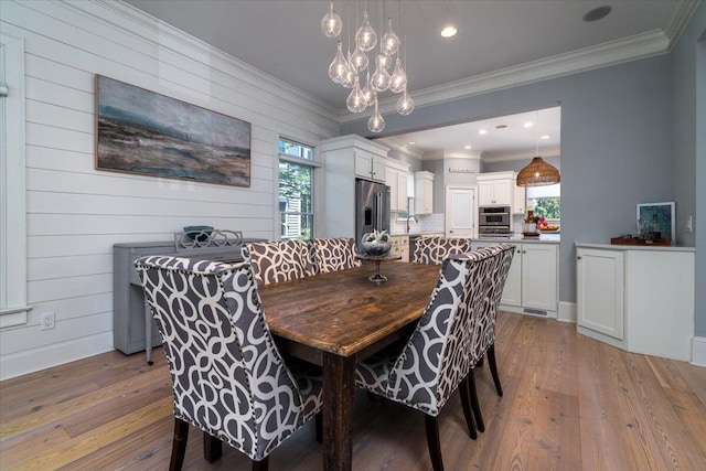 764 Post Oak Dr, Mount Pleasant, SC 29464 - dining space with light wood finished floors, healthy amount of natural light, crown molding, and a chandelier