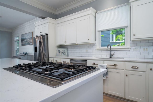 764 Post Oak Dr, Mount Pleasant, SC 29464 - kitchen with gas cooktop, stainless steel fridge, a sink, ornamental molding, and decorative backsplash