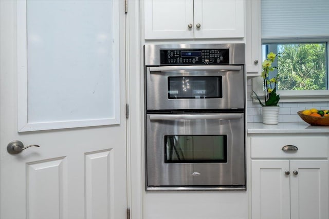 764 Post Oak Dr, Mount Pleasant, SC 29464 - kitchen with stainless steel double oven, white cabinetry, light countertops, and backsplash