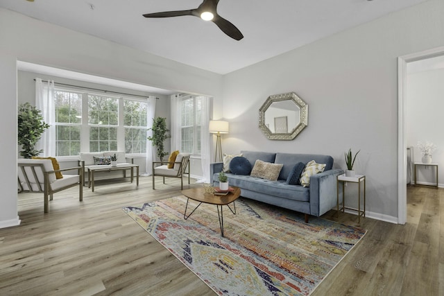 living area with ceiling fan, baseboards, and wood finished floors