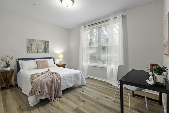 bedroom featuring baseboards and wood finished floors