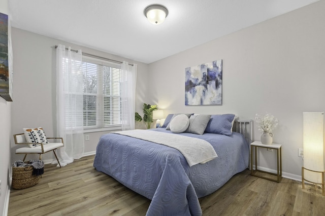 bedroom featuring baseboards and wood finished floors