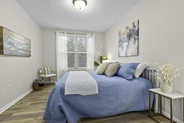 bedroom featuring wood finished floors and baseboards