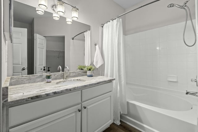 full bath featuring wood finished floors, vanity, and shower / bathtub combination with curtain