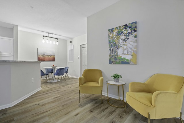 living area with baseboards and wood finished floors