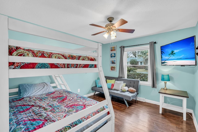 bedroom featuring ceiling fan, dark wood-type flooring, and a textured ceiling