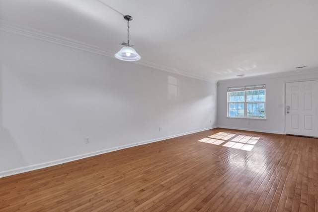 unfurnished room featuring ornamental molding, hardwood / wood-style flooring, and baseboards