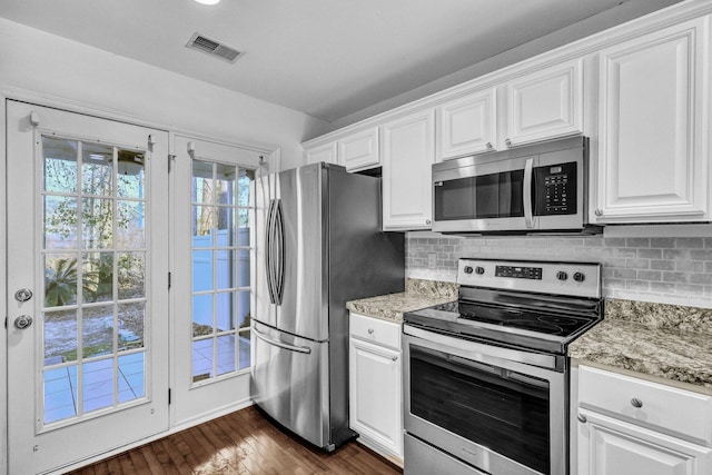 kitchen featuring white cabinetry, visible vents, stainless steel appliances, and backsplash