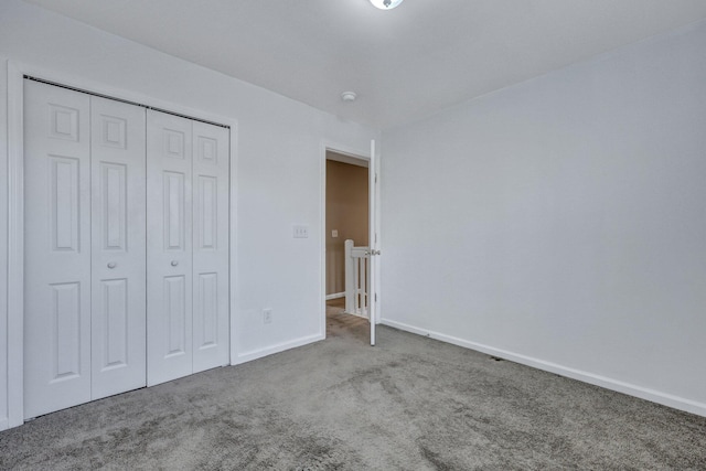 unfurnished bedroom with carpet floors, baseboards, and a closet