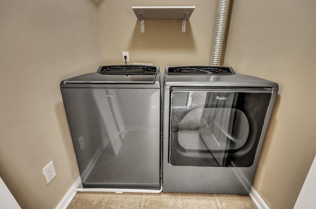 washroom featuring laundry area, washing machine and clothes dryer, and baseboards