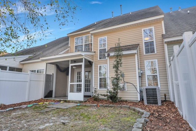 rear view of house featuring a sunroom, central AC, and fence