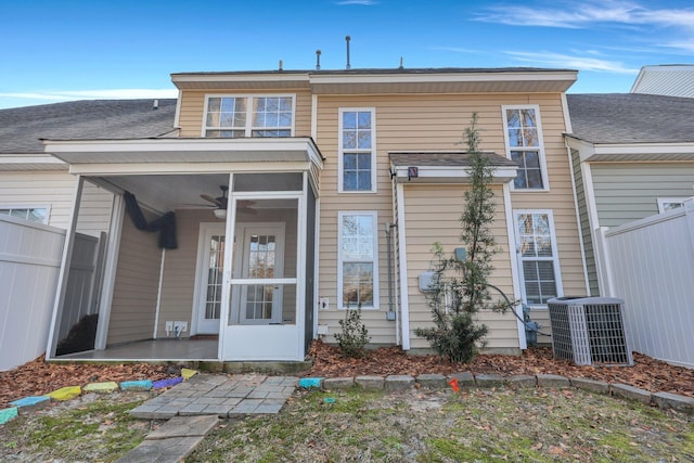 back of property featuring a sunroom, central AC, and fence