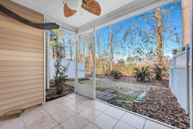 unfurnished sunroom featuring ceiling fan